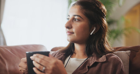 Living room, coffee and listening to music, girl and thinking in morning, radio and online on couch. Home, radio and lounge with podcast, calm and happiness in apartment, streaming and subscriptionの写真素材