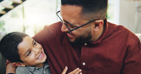 Smile, hug and child with dad on sofa in home relaxing together for fathers day celebration. Happy,...