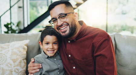 Smile, hug and portrait of child with dad on sofa relaxing together for fathers day celebration. Happy, love and boy kid embracing with man for care, bonding and family time in living room at home.の写真素材