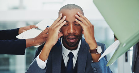 Businessman, headache and stress in office for multitasking, deadline fail or overworked with paperwork. African employee, frustrated and time management with accountability, mental health or burnoutの写真素材