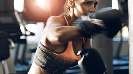 Fitness, boxing and woman with punching bag in gym for self defense training, cardio workout or...