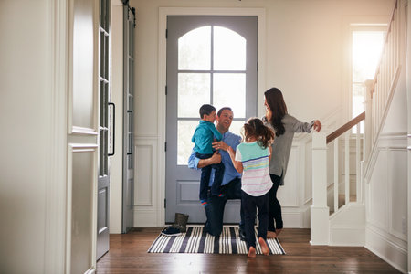 Hello, door and parents with kids hug in home for greeting, welcome and bonding. Family, happy and mother, father and children in house embrace for affection, relationship and excited for returnの写真素材