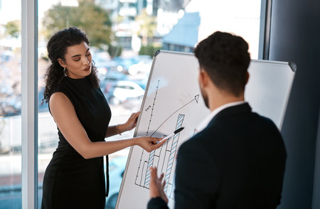 Business people, meeting and board with discussion in office for kpi growth, solution and brainstorming. Man, woman and teamwork with graph at workplace for sales review, planning and communicationの写真素材