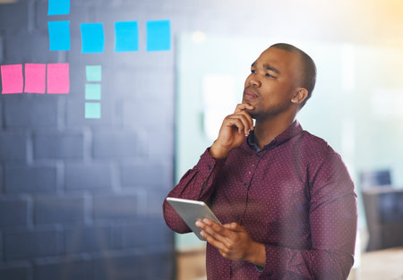Glass, thinking and businessman with tablet by sticky note for investment, research and kpi growth...