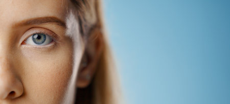 Eyes, woman and portrait with mockup and test for care and wellness with microblading and cosmetics in studio. Dermatology, skincare and eyebrow waxing with makeup and skin glow with blue backgroundの写真素材