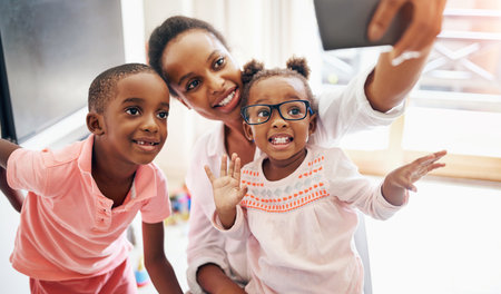 Mother, children and selfie with love in home for parenthood memory, moments together and happiness. Mom, boy and girl with photography in house for bonding or post on social media and personal blog.の写真素材