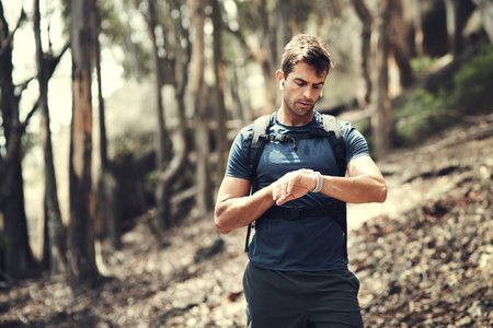 Man, hiking and walking with fitness watch in nature for workout, sports and health on the mountain....