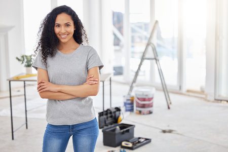 Woman, portrait and tool box for diy project or home improvement as carpenter in house for renovation. Female person, arms crossed and contractor in building for maintenance, safety on propertyの写真素材