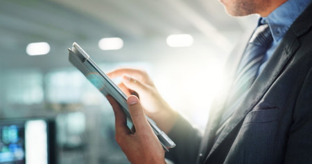 Hands, tablet and business employee in office for connection, information or research with flare. App, social media and technology with professional in corporate workplace for email communicationの写真素材