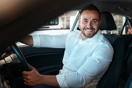 New car, dealership and portrait of happy man in vehicle for purchase, good service or loan success. Customer, driving and proud driver in showroom for transportation, automobile shopping or warrantyの写真素材