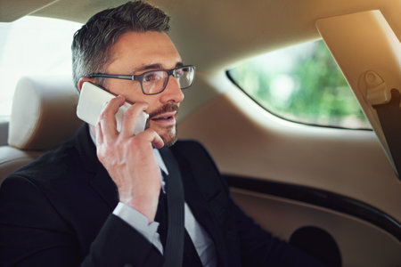 Man, phone call and travel in car for conversation, networking or listen for deal for company. Person, vehicle and smartphone for thinking, transportation or commute with negotiation on business tripの写真素材