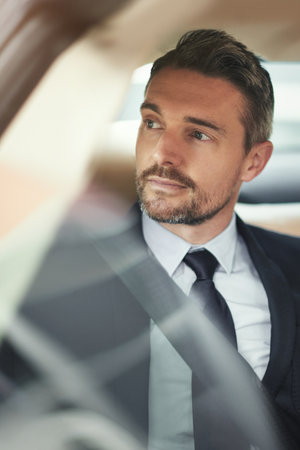 Thinking, corporate and man in car for travel or commute to airport for business meeting in city. Transportation, male person and executive with idea for concierge service for traffic in New Yorkの写真素材