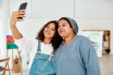 Creative women, selfie and art studio for canvas, bonding and happy for learning, paint class. Girl friends, smile and photography for memory, profile picture and workshop for post on social networkの写真素材