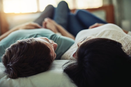 Bedroom, couple and happy with love, relax and marriage for commitment, bonding together and affection. Romance, man and woman rest, care or relationship with support, conversation and trust in homeの写真素材