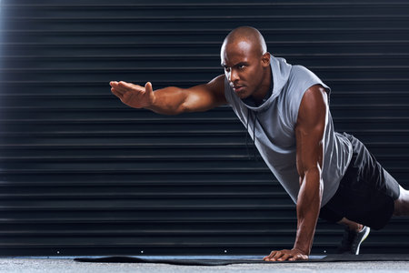 Male athlete, exercise and pushup with hand for balance, sport or toning in fitness studio. Healthy,...