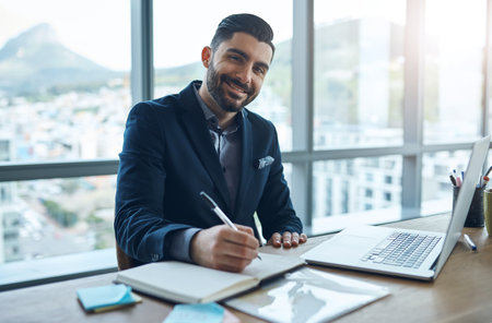 Laptop, notes and portrait of business man in office for financial analysis, company review and data analytics. Corporate, consultant and person writing on computer for research, website and planningの写真素材