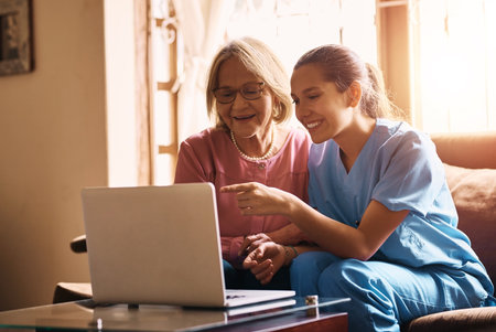 Healthcare, insurance or laptop with nurse and old woman on sofa in living room of retirement home. Computer, medical or pointing and caregiver with senior patient in apartment for consultingの写真素材