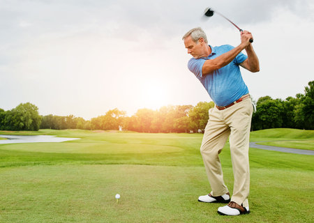 Mature, man and swing on field for golf or ball for improve balance, coordination and retirement leisure with relax. Golfer, club and play on grass for physical activity, mobility and outdoor sport.の写真素材