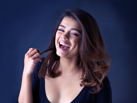 Hair care, happy and portrait of woman with beauty, cosmetic and natural treatment for confidence. Smile, salon and female person with shampoo routine for shiny hairstyle by studio background.の写真素材