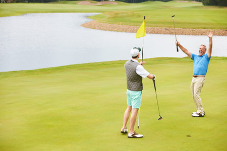 Men, golf and win with celebration in game as members in club for health, success in business. Male people, putter and golfer score with sport, exercise and networking for company at tee offの写真素材