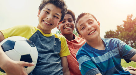 Soccer, friends and portrait of children in park with ball for playing, having fun and sports outdoors. Childhood, youth and happy boys for games on holiday, vacation and weekend together in natureの写真素材