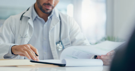 Hands, doctor and patient with consultation, documents and conversation for wellness, insurance and healthcare. Closeup, people and medical with professional, paperwork and discussion for resultsの写真素材