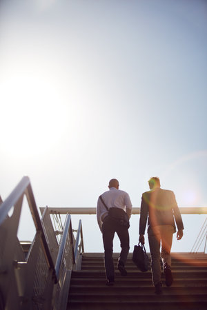 Business, men and walking on stairs in morning for commute to work with communication and low angle. People, back and travel on steps in city for conversation, networking and partnership mockup spaceの写真素材