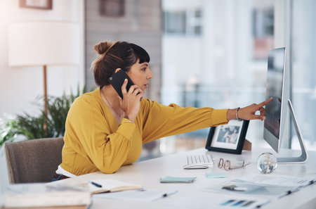 Woman, phone call and computer with pointing in office with discussion, reading and contact for deal. Person, receptionist and smartphone to check schedule on pc for consultation at creative agencyの写真素材