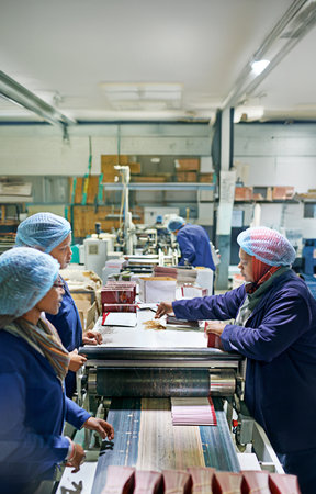 Group, people and manufacturing paper for printing by machine, assembly line and production at job. Manager, employees and system in industrial warehouse for design, brochure and guide with teamworkの写真素材