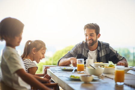 Love, family and father with kids at breakfast table on patio for morning, conversation and bonding at home. Food, wellness and dad with children outdoor for diet, nutrition and gut health balanceの写真素材