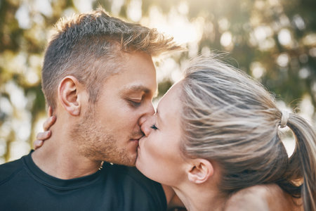 Happy couple, kiss and nature with love for embrace, care or support together at outdoor park. Closeup of man, woman or lovers with intimacy, affection or bonding for romance, date or anniversaryの写真素材