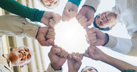Fist bump, low angle and friends with fashion, circle and support for motivation, smile and happiness. Mockup space, group or people in city, hand gesture or trendy with teamwork, confidence or styleの写真素材