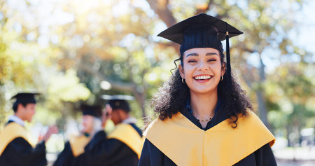 Happy woman, portrait and graduation with hat in nature for outdoor ceremony, scholarship or qualification. Female person, student or graduate with smile for education or higher certificate at parkの写真素材
