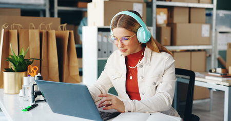 Woman, laptop and small business with headphones, reading and logistics for thinking, sales report...