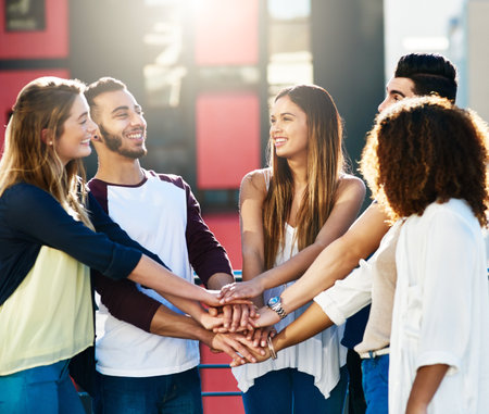 Friendship, hands and together for motivation, celebration and success for vacation outdoor. Happy people, men and women with huddle or stack for support, solidarity and travel in city of Parisの写真素材