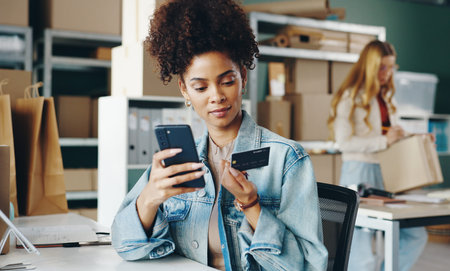 Ecommerce, black woman and smartphone in warehouse for sales, shopping and checkout with credit...