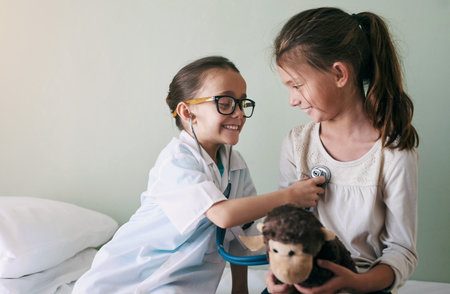 Girls, children and doctor with dress up, kids and fun with game, fantasy and pretend with stuffed toy. Play, joyful and medical with weekend break, stethoscope and career choice for developmentの写真素材