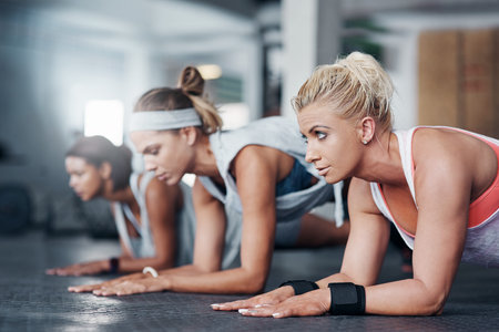 Fitness, wellness and planks with group for exercise, healthy workout or training in gym for weight...