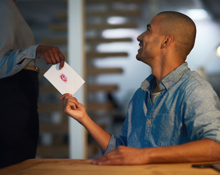 Smile, man and letter for love in office romance, coworking and secret admirer in startup business. Flirting, employee and giving note, gift or hand offer paper card with kiss for message at workの写真素材