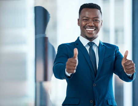 African businessman, portrait and thumbs up in office for achievement and success in career. Trader, professional and promotion in corporate company for goals, development and happiness for bonusの写真素材