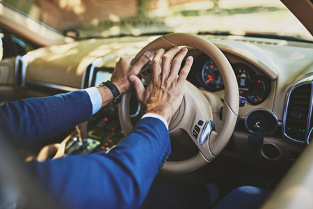 Man, hands and horn in car for driving, hooting and pressing steering wheel for caution warning or road rage. Travel, work commute and morning or attention sound, driver and enroute with professionalの写真素材