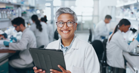 Portrait, scientist and happy woman in laboratory with tablet for medical research and job as biologist. Digital, science and face of mature doctor on tech with glasses for pharma study or innovationの写真素材