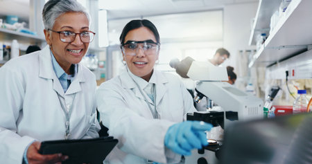 Laboratory, women scientist and teamwork with microscope for medical research and diagnosis with...