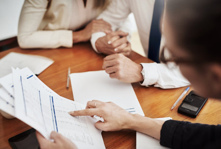 Business, planning and hands for accounting, paperwork and project with discussion and budget. Financial advisor, people and couple for partnership, future and feedback for real estate mortgageの写真素材