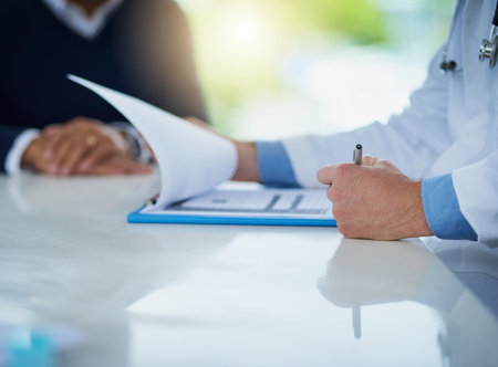 Doctor, hands and paperwork for consultation or checkup in clinic, report and treatment for healthcare. Specialist, signature and medical records for patient diagnosis, insurance and plan recoveryの写真素材