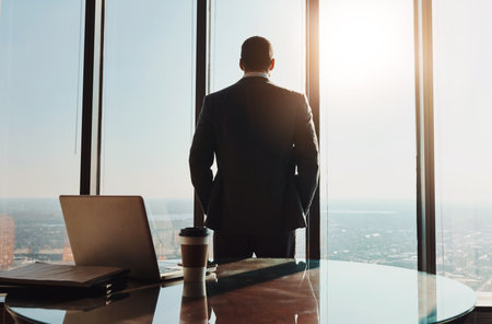 Business, man and back thinking at window in office with city view for legal case ideas and solution. Law firm, thoughtful advocate and professional or contemplating client defense for court trialの写真素材