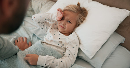 Home, father and sick girl in bed, cold flu and fever with support, care and disease. Family, dad and daughter in bedroom, pain and parent monitoring illness, comfort or compassion with love in houseの写真素材