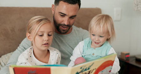 Father, children and reading in bed for storytelling, literature and family bonding at bedtime. Home, daddy and kids learning together for listening, language and support or fiction for fairytaleの写真素材