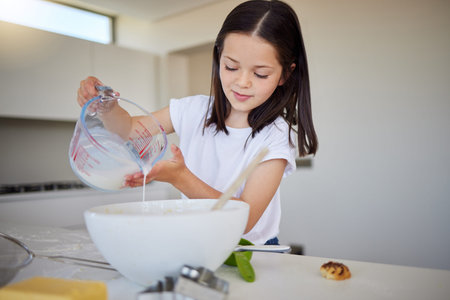 Kitchen, baking and child with ingredients, smile and preparing of dessert, growth and development....