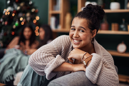 Christmas, portrait and happy woman relax in home with friends on holiday in living room. Face, xmas and smile of girl on sofa for festive celebration, bokeh and party at social gathering in houseの写真素材